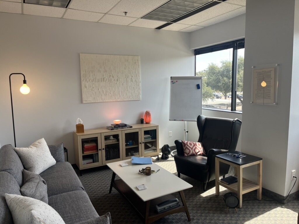 Counseling room with a sofa, chair, warm lamp, and window